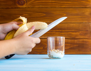 Ingredients for banana dessert on a wooden background. Cuts a banana