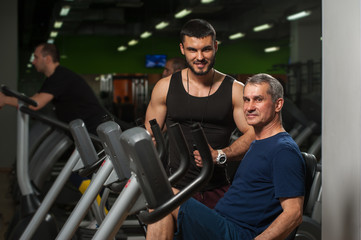 Fototapeta na wymiar Smiling personal trainer working with male client