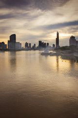Fototapeta na wymiar View of the Chao-Phraya-River at dawn with gray cloud cover. Bangkok, Thailand