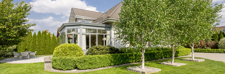 Fototapeta na wymiar House exterior with orangery in well-kept garden