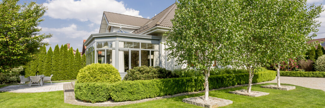 House Exterior With Orangery In Well-kept Garden