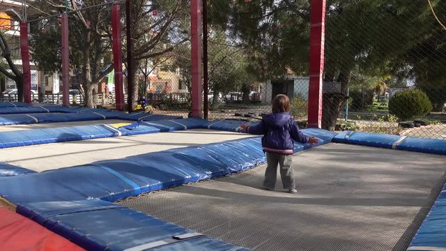 4K Boy claps hands jumping on trampoline 