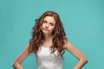 Portrait of an angry woman looking at camera on a blue background