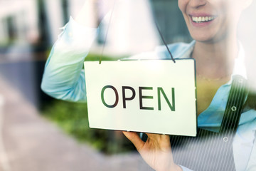 Woman holding open sign in cafe
