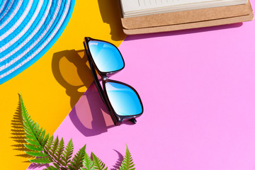 Blue hat and sunglasses on colorful paper