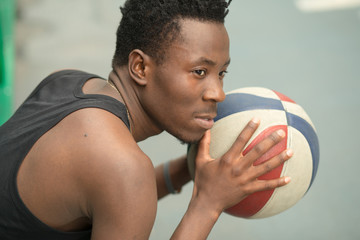 Portrait of african american man sitting on basketball court