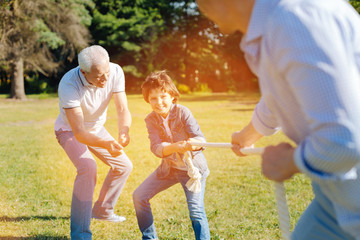 Fototapeta premium Enthusiastic committed fun men tugging the rope