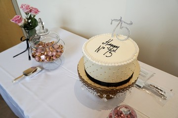 Birthday cake display with tablecloth foiled candy and roses in a vase or anniversary celebration classy beaded round cake