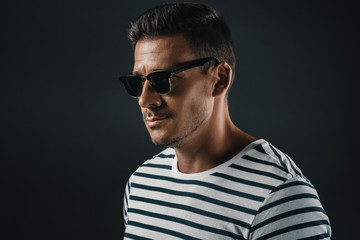 Obraz premium portrait of stylish man in striped t-shirt and sunglasses, isolated on grey