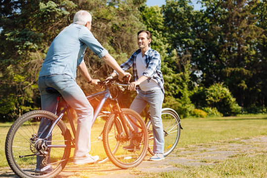 Joyful easy going man and his son meeting for ride