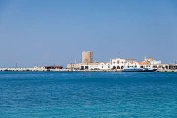 Fototapeta premium Harbor and monuments in Rhodes. Old defensive stands and windmills. Wharf harbors, boats and sailing ships. Historic harbor, pier and beach.