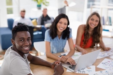 Fototapeta premium Young business colleagues working on laptop in the office