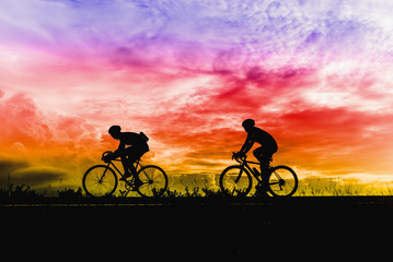 Obraz na płótnie Canvas Silhouette of sportsmen riding a bicycle