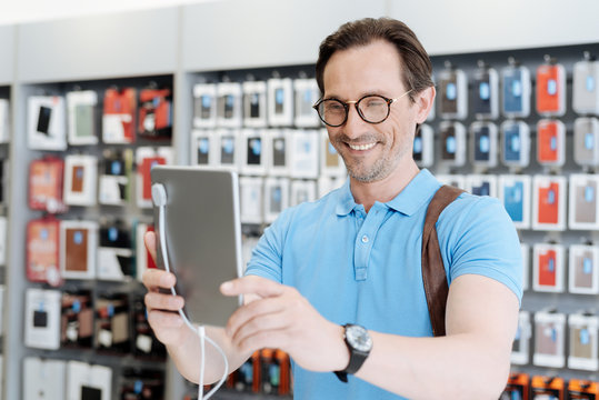 Man in glasses taking self portrait with digital tablet