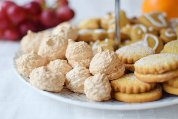 Several types of pastry with coconut macaroons, filled cookies and honey cakes on a multi layer...