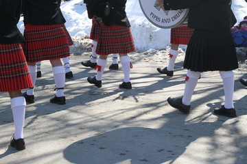 Parade of scottish players feet marching on a road 