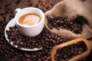 Coffee cup close-up over dark roasted coffee beans