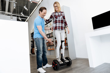 Fototapeta na wymiar Salesman assisting female customer with self balancing scooter