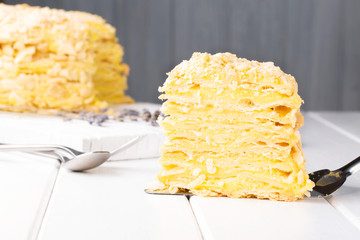 Napoleon cake with lavender custard on a white wooden background, selective focus, horizontal
