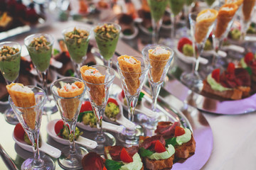 Beautifully decorated catering banquet table with different food snacks and appetizers on corporate...