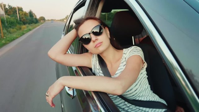 Attractive young woman looks out the car window. Dream of traveling