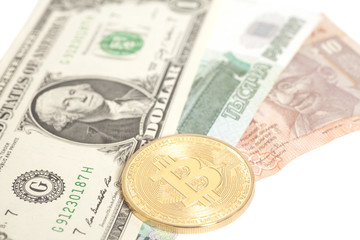 Golden bitcoin with U.S. dollar,ruble end rupee banknotes isolated on white