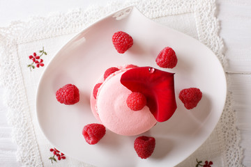 Beautiful macaroon with raspberries close-up on a plate. Horizontal top view