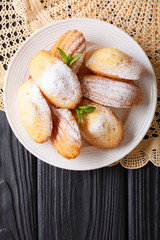French biscuit Madeleine close-up on a plate on the table. Vertical top view