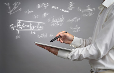 Man scientist or student holding tablet PC and working with various high school maths and science...