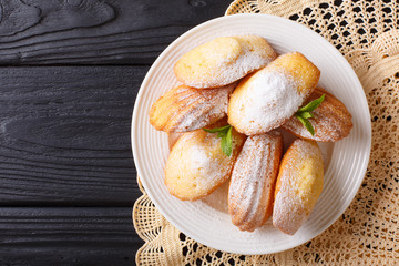 French biscuit Madeleine close-up on a plate on the table. Horizontal top view