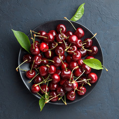 Sweet cherry in black plate on blue stone background. - 162751645