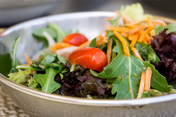 Delicious fresh salad with tomatoes, lettuce, eggplant, zucchini, cheese, parma ham and olive oil