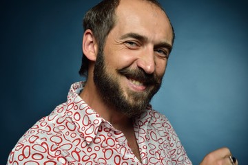 Portrait of a man on a dark background, with a mustache and beard