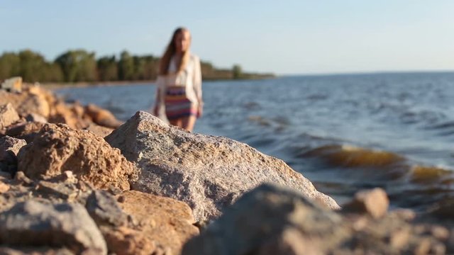 Young graceful woman walking barefoot on seaside