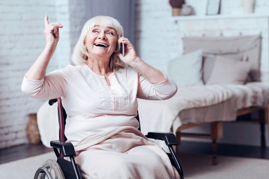 Positive Disabled Aged Woman Talking On Smart Phone At Home