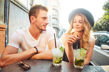 Young couple sitting at cafe and having fun  