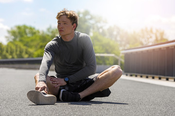 Obraz premium Exhausted man resting after jogging in full sun