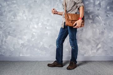 Vintage travelling men fashion with leather bag handsome thin man over loft concrete wall style.