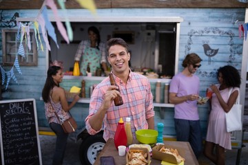 Portrait of happy man holding beer bottle