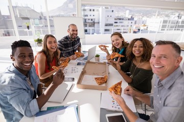 Portrait of happy executives having pizza