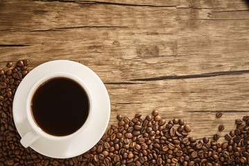 Cup of coffee and coffee beans with wooden table