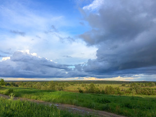 Fototapeta premium Cloudscape over river valley at sunset 