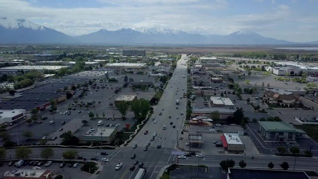 Aerial busy business street urban cityscape fast motion. Aerial overhead drone footage business road mountain valley. Home of Brigham Young University, BYU. Metropolitan city center.