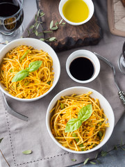Lunch with curry pasta noodles in bowls and vegetables with turmeric
