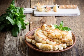 Roasted organic cauliflower steak on wooden board