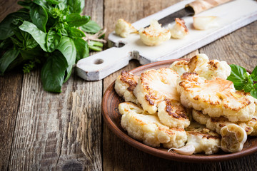 Roasted organic cauliflower steak on wooden board