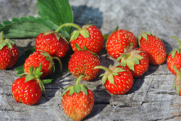 Fresh red natural strawberries and leaf on old cracked wooden background