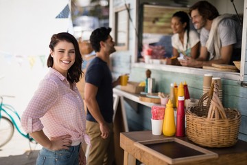 Portrait of smiling woman standing with hand on hip