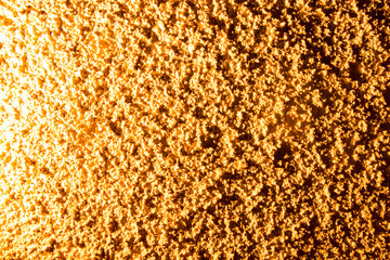 Plaster on a wall in gold lighting as a background