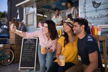 Friends taking selfie from mobile phone in food truck van
